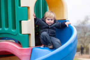 young boy in Pennywell farm going down a slide