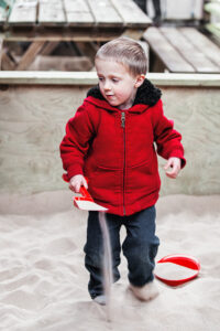 young boy in Pennywell farm playing in sand.
